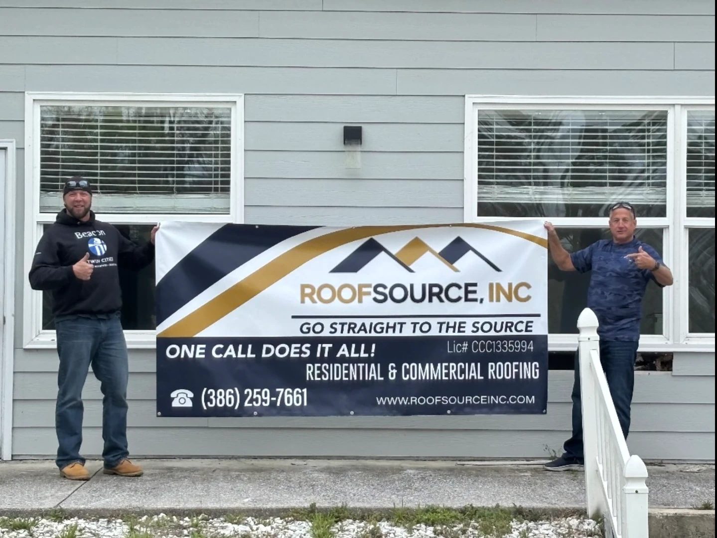 RoofSource Inc crew holding a real company banner reading Go Straight To The Source