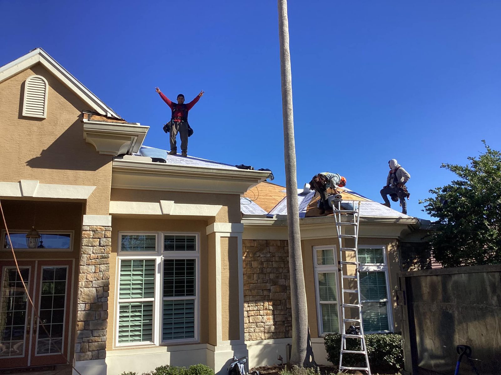 RoofSource crew on a roof tear-off under clear Florida skies